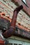 Rusty exit pipe on side of old school