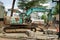 The rusty green excavator work at road construction site