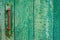Rusty green handle of door on green wood door with cracked and scratch. Horizontal grunge texture