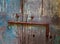 Rusty horizontal lag bolt on weathered wooden door