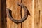 Rusty horseshoe on old wooden background. Outdoors image on a sunny day