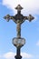 Rusty iron cross in an old cemetery. Crucifix against the sky with clouds
