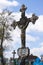 Rusty iron cross in an old cemetery. Crucifix against the sky with clouds and old crosses