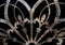 Rusty iron grunge lacy metal decoration with fleur-de-lis isolated on black
