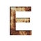 Rusty iron letters. The letter E cut out of paper on the background of an old rusty iron sheet with rust stains and cracks.