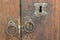 Rusty iron ring door knobs and keyhole over an old wooden grunge door