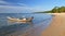 Rusty long tail boat on the sand seashore