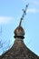 Rusty lopsided cross at the top of a dome