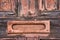 Rusty mail slot on wooden door