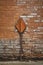 rusty metal arrow pointing upwards on brick wall