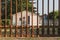 Rusty metal cemetery fence with gravestone in background