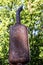 Rusty metal exhaust pipe of an old tractor on a background of green forest. View from below