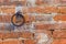 A rusty metal ring embedded in a brick wall. Copy space