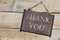 Rusty metal sign on wooden table, text thank you