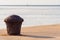 Rusty mooring bollard on concrete pier with blue sea with sailboat on horizon