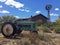 Rusty old tractor on a farm with a windmill