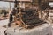 Rusty old type writer of unknown brand sits on a vintage wooden barrel in the desert sun