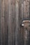 A rusty padlocked bolt on weathered wooden gate