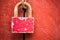 Rusty pink padlock is on the red wall