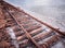 Rusty razy rails and rotten sleepers covered of salt on old railroad tracks on a mound at salt mining lake near brine