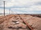 Rusty razy rails and rotten sleepers covered of salt on old railroad tracks on a mound at salt mining lake near brine