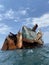 Rusty remains of a sunken ship submerged in water