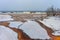 Rusty river under thin ice with waves on the background