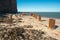 Rusty steel beams, remnants of old ocean pier, on the beach of Helgoland island, Germany. Tall red cliffs in the