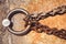 Rusty steel ring and mooring lines in a seaport. Rusty iron chain on the concrete ground