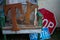 Rusty ``T`` and `X` letters on a wooden chair with stop and south road signs in background