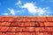 Rusty tiles of old roof over blue sky