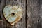 Rusty trim on keyhole as heart on old wooden door.