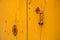 Rusty vintage keyhole on a yellow door