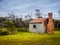 Rusty vintage shed with brick chimney against gum trees