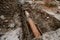 Rusty water pipe in the trench ground view