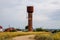 Rusty water tower against sky. Old water pump