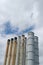 Rusty weatherworn old smokestacks against cloudy sky