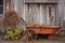 rusty wheelbarrow leaning against a weathered barn wall