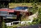 Rusty wreck of a historic american car on a meadow