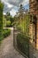 Rusty wrought iron gate opening into walled garden Englan