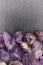 Rutilated amethyst jewel heap on black stone half background. Place for text