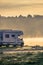 Rv caravan on lake shore. Autumn time, foggy morning