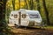 An rv parked in a wooded area in the fall. Digital image.