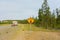 An rv and tow car approaching a gravel road in the yukon territories