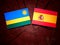 Rwanda flag with Spanish flag on a tree stump