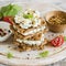 Rye biscuit with cheese, cucumber and cilantro on a light wooden background