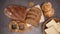 Rye bread, organic bagels with sesame and flax, buns and toast bread appear on kitchen table with pile of grain - Stop motion