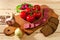 Rye bread, sausage, meat, cutting board, radish, tomatoes, onions, greens, garlic herb and spices on wooden background