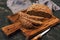 Rye bread with seeds is cut on a cutting board. Round rye bread on a dark background. Selective focus.