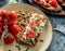 Rye bread toasts with goat cheese, tomatoes on plate on blue background with baked sweet potato toasts with roasted chickpeas,